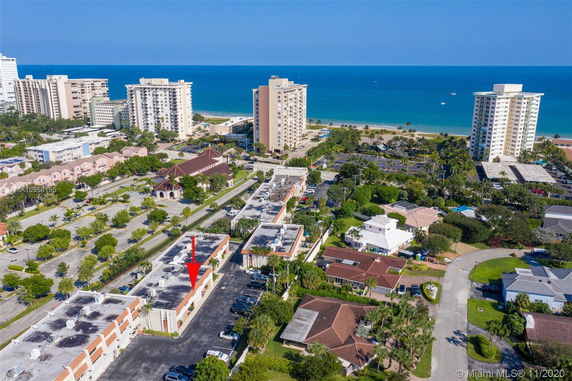 Panoramic view of a coastal area with residential and commercial buildings near the beach.