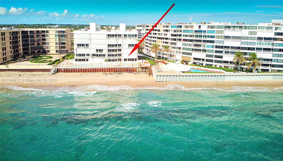 View of beachfront buildings with a red arrow indicating a specific location.
