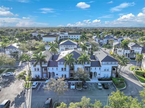 Aerial view of a residential area with multiple multi-story buildings and parking spaces.