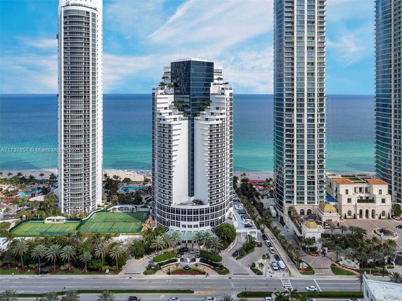 Front view of three high-rise residential towers facing the ocean.