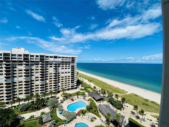 High-rise building near the beach with a swimming pool area and ocean view.