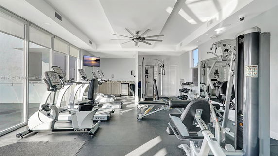 Indoor gym area with exercise equipment, treadmills, and weight machines.