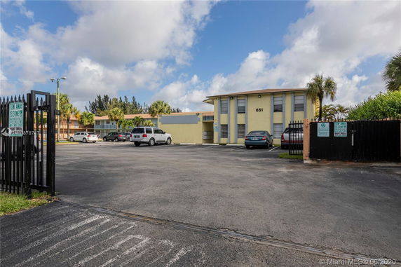 Outdoor parking area in front of a multi-story building.