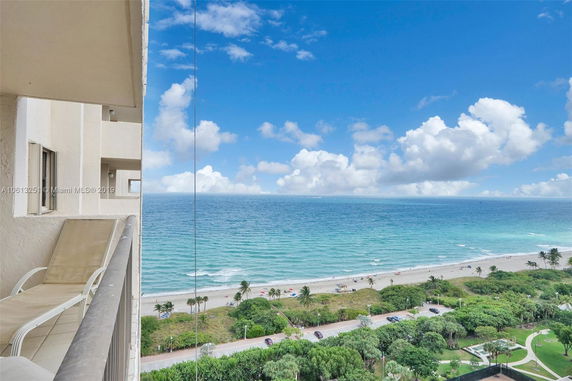 Panoramic view from a balcony overlooking the ocean and beach.