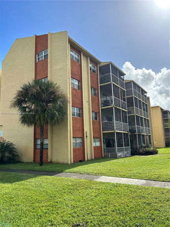 Front view of a multi-story apartment building with screened balconies.
