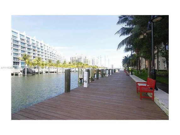 View of a waterfront area with a boardwalk and apartment buildings.