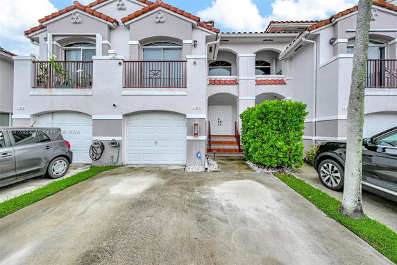 Front view of a townhouse with a double garage and a small balcony.