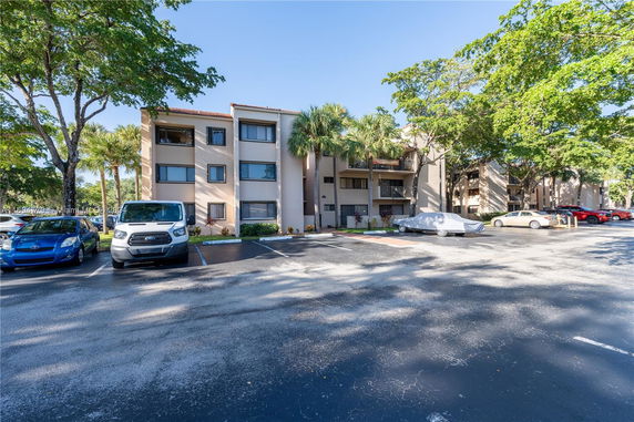 Outdoor parking area in front of a multi-story residential building.
