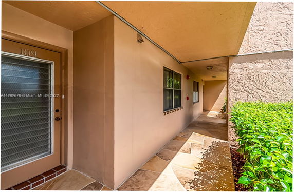 Exterior view of a building entrance with a walkway and door number 109.