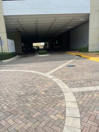 Covered outdoor parking area under a building.