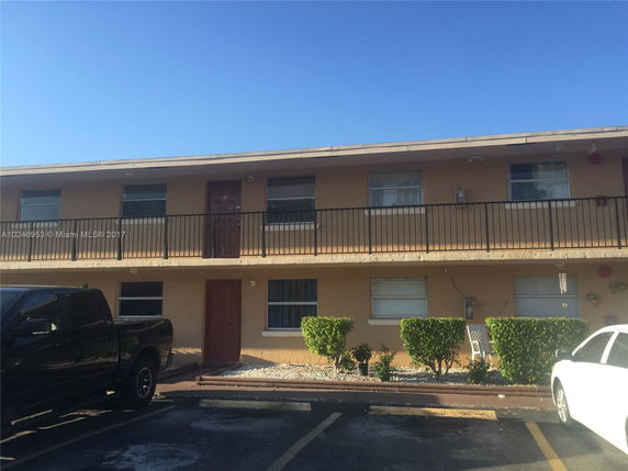 Front view of a two-story apartment building with a balcony.