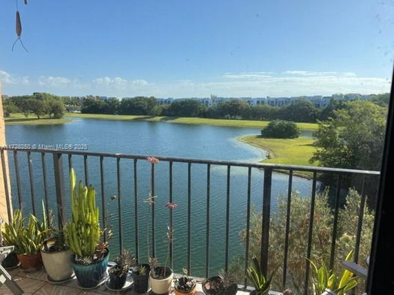 View from a balcony overlooking a lake and grassy landscape.