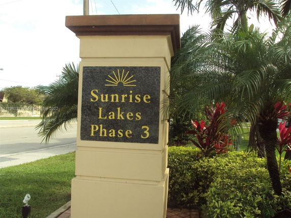 Signage for Sunrise Lakes Phase 3 near a road.