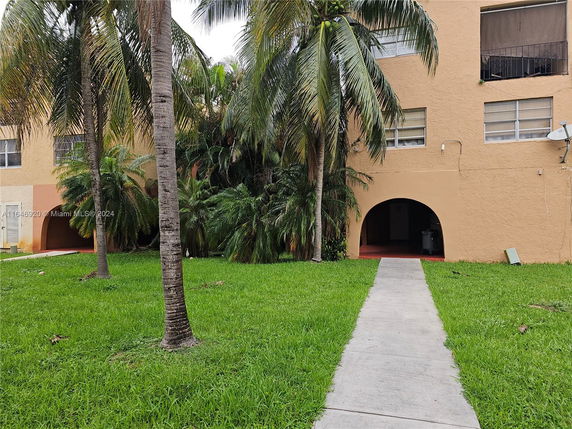 Front view of a building with arched entrances and multiple windows.