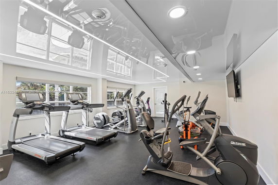 Interior view of a gym with various exercise equipment including treadmills and elliptical machines.