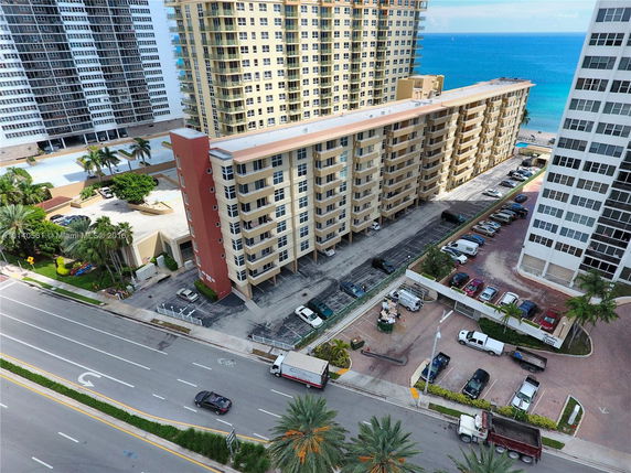 Aerial view of a multi-story beachfront apartment building.
