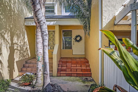 Front view of a house with an entrance featuring steps and a door with a wreath.
