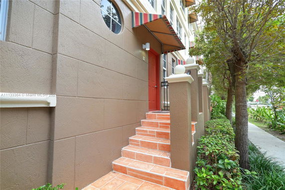 Front view of a building entrance with stairs and an awning.