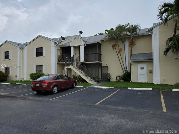 Front view of a two-story apartment building with exterior stairs.