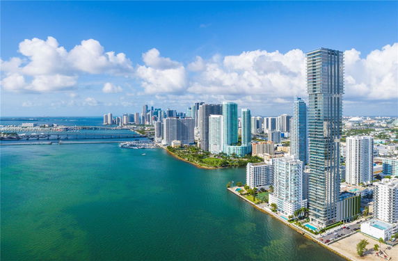 Panoramic view of a coastal city skyline with high-rise buildings near the waterfront.