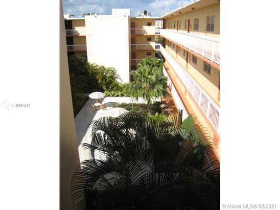 View of a multi-story apartment building with balconies and plants.