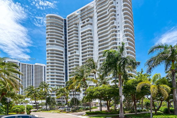 Front view of a multi-story residential building with numerous balconies.