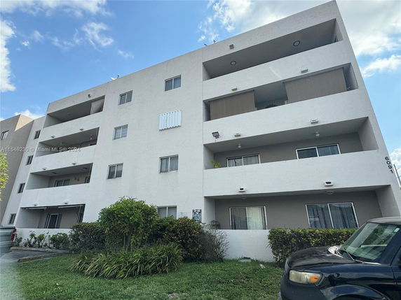 Front view of a multi-story residential building with balconies.
