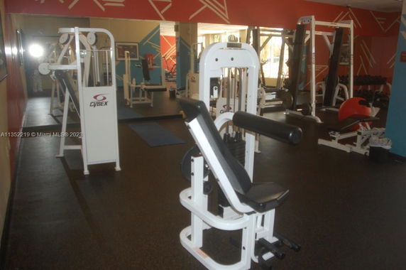 Indoor gym area with various exercise equipment and machines.
