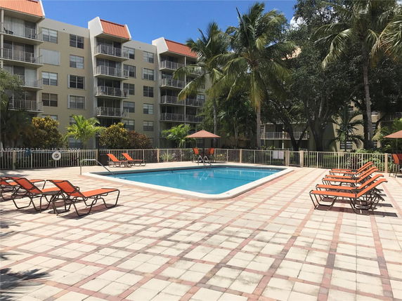 Outdoor swimming pool area surrounded by apartment buildings.