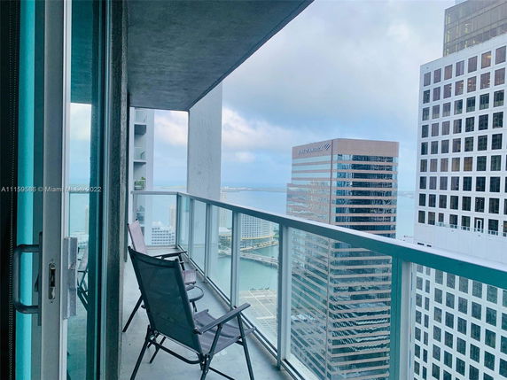 View from a balcony overlooking high-rise buildings and a body of water.