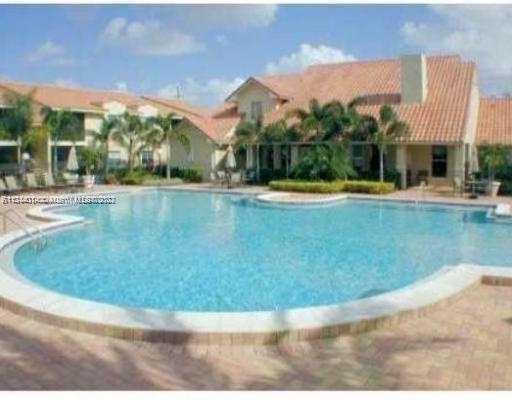 Outdoor swimming pool area with surrounding residential buildings.