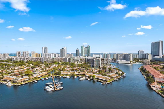 Wide-angle view of a coastal city with waterway and high-rise buildings.