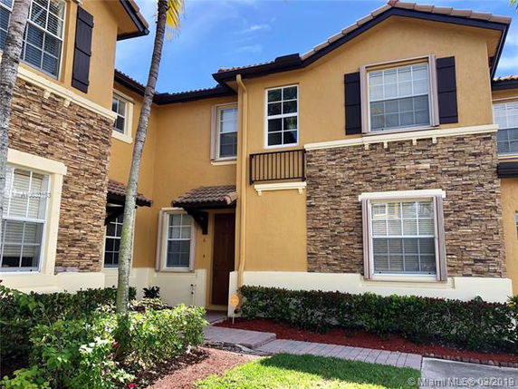 Front view of a two-story townhouse with stone and stucco façade.
