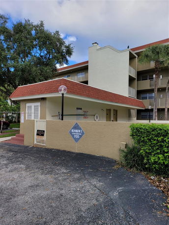 Front view of a multi-story condominium building with a sign reading 'Sunrun I Condominium 3120'.