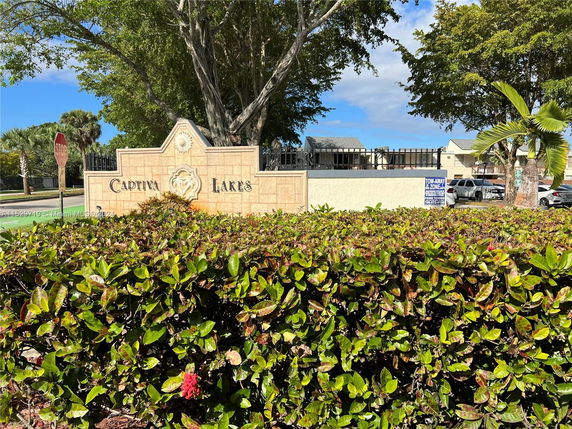 Entrance sign for Captiva Lakes with greenery and trees around it.