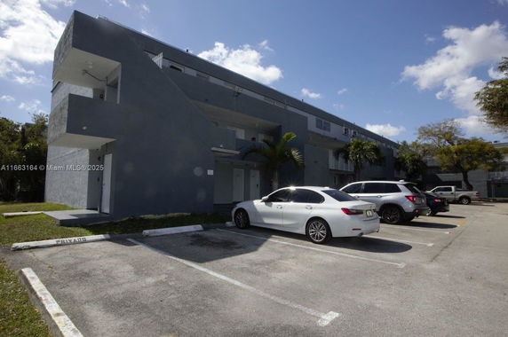 Front view of a multi-story building with parking spaces.