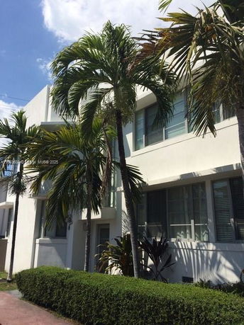 Front view of a multi-story building with palm trees.