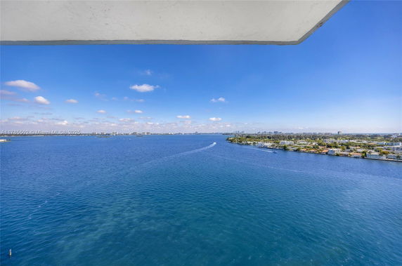 Wide angle view of a water body and distant skyline under a blue sky.
