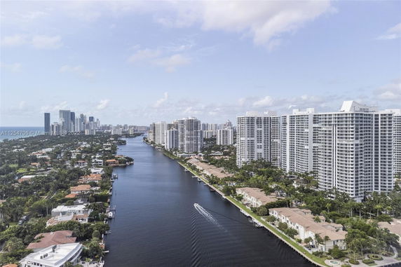 Panoramic view of a city skyline along a waterway with high-rise buildings.