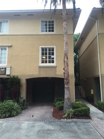 Front view of a multi-story townhouse with a garage entrance.