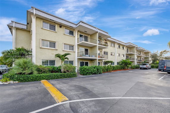 Front view of a multi-story apartment building with balconies.