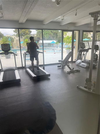 Gym area with exercise equipment and large windows.