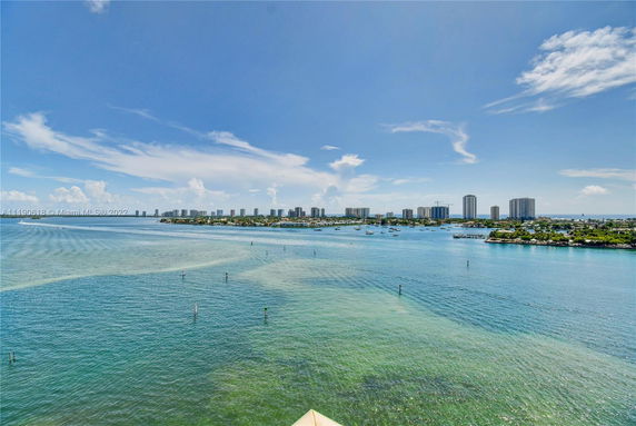 Panoramic view of a coastal area with buildings and boats visible in the distance.