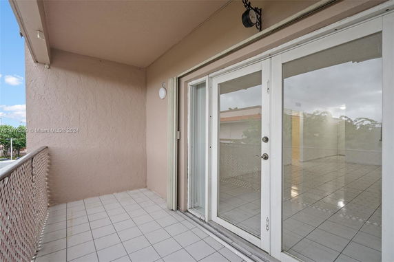 View from a balcony with sliding glass doors and tiled flooring.