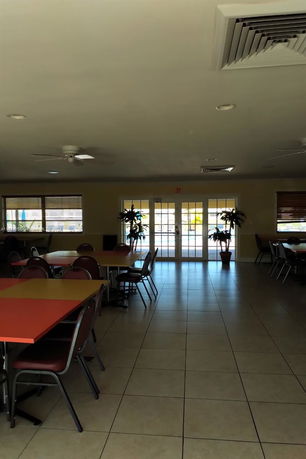 Indoor area with tables and chairs, likely a common recreational space.