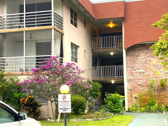 Front view of a multi-story building with balconies and a red brick exterior.