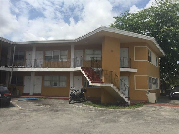 Front view of a two-story apartment building with external staircases.