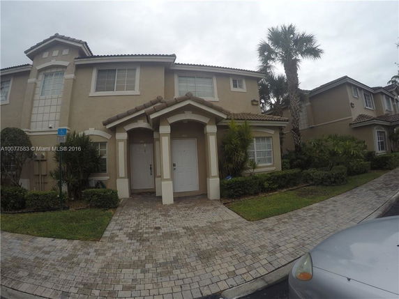 Front view of a two-story house with a tiled roof and double entrance.