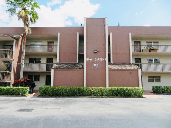 Front view of a multi-story apartment building with balconies.