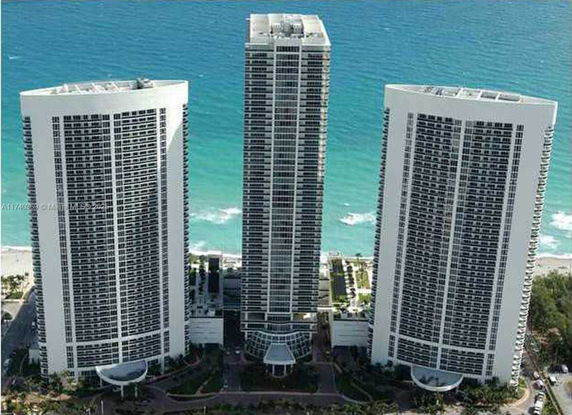 Front view of three high-rise buildings near the coastline.